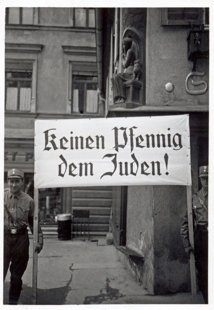 Zwei uniformierte SA-Männer, die ein Plakat mit der Aufschrift "keinen Pfennig dem Juden!".
